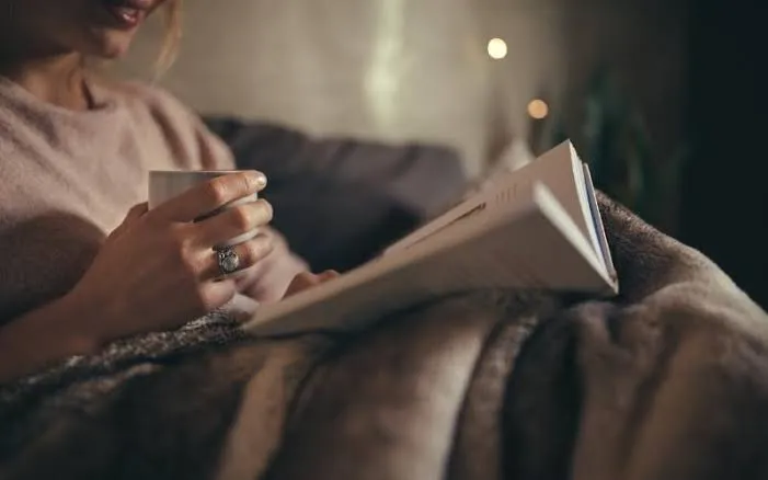 Warm ceramic mug beside an open notebook at twilight